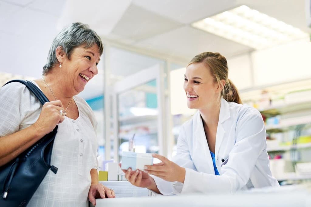 A pharmacist handing a medicine box to a customer at the counter